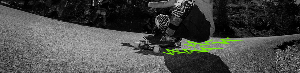 Un longboarder penché dans un virage serré à pleine vitesse.